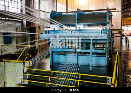 Johannesburg, Südafrika - 16. Oktober 2012: Weitwinkelansicht von Kabelspulen auf einer großen Maschine in einer Förderbandfabrik Stockfoto