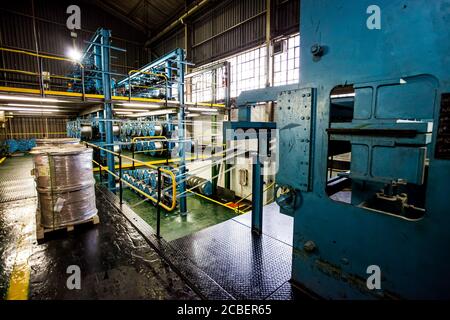 Johannesburg, Südafrika - 16. Oktober 2012: Weitwinkelansicht von Kabelspulen auf einer großen Maschine in einer Förderbandfabrik Stockfoto