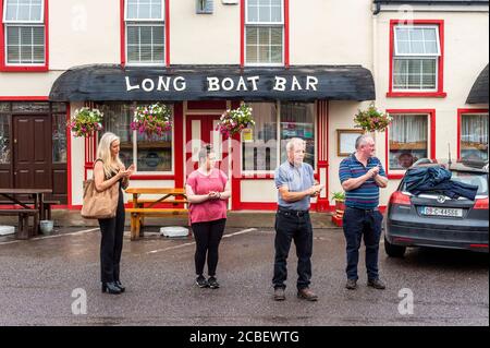 Durrus, West Cork, Irland. August 2020. Ex Fine Gael TD Paddy Sheehans Begräbniskortege passiert Durrus auf dem Weg zu Mr. Sheehans Begräbnisfeier in Goleen, West Cork. Ungefähr 50 Menschen sagten Herrn Sheehan ein letztes Auf Wiedersehen, wobei die Leute in eine Runde Applaus brachen, als der Leichenwagen mit Herrn Sheehans Sarg vorbeiging. Quelle: AG News/Alamy Live News Stockfoto