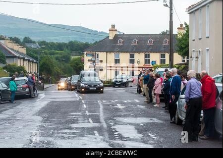 Durrus, West Cork, Irland. August 2020. Ex Fine Gael TD Paddy Sheehans Begräbniskortege passiert Durrus auf dem Weg zu Mr. Sheehans Begräbnisfeier in Goleen, West Cork. Ungefähr 50 Menschen sagten Herrn Sheehan ein letztes Auf Wiedersehen, wobei die Leute in eine Runde Applaus brachen, als der Leichenwagen mit Herrn Sheehans Sarg vorbeiging. Quelle: AG News/Alamy Live News Stockfoto