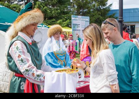 Jekaterinburg, Russland, 15. Juni 2019. Auf den Händen eines Mannes Baschkir baursak in einem Teller mit einem ethnischen Muster. Ein Paar, das sich verwöhnen lassen kann. Der nationale Urlaub Stockfoto