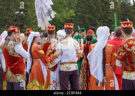 Jekaterinburg, Russland, 15. Juni 2019. Ein Mädchen und ein Kerl in tatarischen Nationalkleidung umarmen sich zwischen einer Menschenmenge. Der jährliche Nationalfeiertag der T Stockfoto