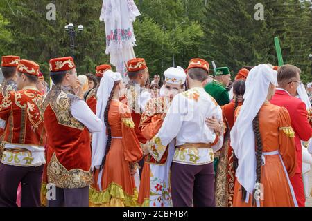 Jekaterinburg, Russland, 15. Juni 2019. Ein Mädchen und ein Kerl in tatarischen Nationalkleidung umarmen sich zwischen einer Menschenmenge. Der jährliche Nationalfeiertag der T Stockfoto