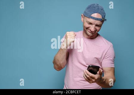 Zufriedener Mann hat Spaß, mit seinen Freunden auf einem Videoanruf zu sprechen, er lächelt und macht eine Handbewegung. Speicherplatz kopieren. Stockfoto