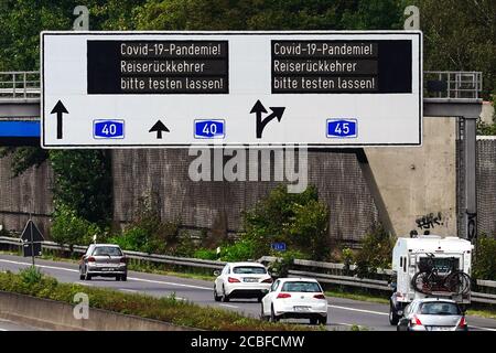 Dortmund, 13. August 2020: Antrag auf Prüfung des Coronavirus aufgrund der Covid-19-Pandemie an zurückkehrende Reisende. Schilderbrücke auf der Autobahn A40 im Raum Dortmund --- Dortmund, 13.8.2020: Beaufragung an Reiserückkehrer, sich aufgrund der Covid-19-Pandemie auf das Coronavirus testen zu lassen. Schilderbrücke auf der Autobahn A40 nahe Dortmund. Stockfoto