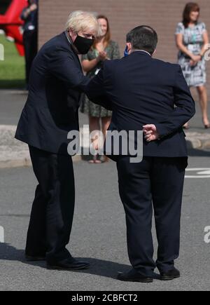 Premierminister Boris Johnson stößt mit dem nordirischen Gesundheitsminister Robin Swann auf Ellenbogen, als er während seines Besuchs in Belfast am Hauptsitz des nordirischen Rettungsdienstes ankommt. Stockfoto