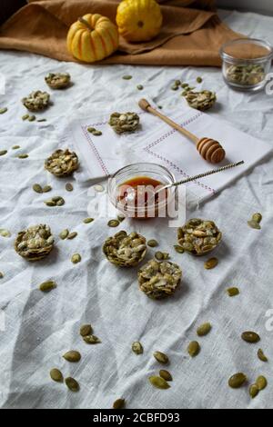 Bio-Süßigkeiten mit Kürbiskernen. Fitness-Cookies auf einer Leinentischdecke. Einfarbige Farben Stockfoto