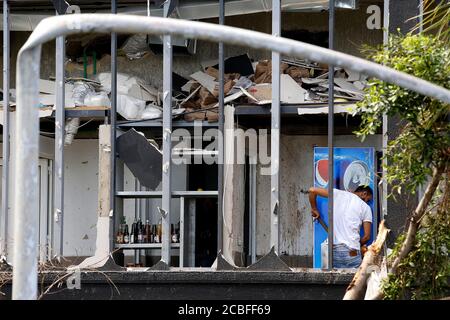 Beirut, Libanon. August 2020. Ein Mann reinigt das Chaos in einem beschädigten Gebäude in Beirut, Libanon, 13. August 2020. Am 4. August erschütterte zwei riesige Explosionen den Hafen von Beirut, erschütterte Gebäude in der Hauptstadt des Libanon, tötete 171 Menschen und verletzte mindestens 6,000. Quelle: Bilal Jawich/Xinhua/Alamy Live News Stockfoto