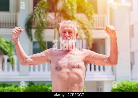Starke gesunde ältere Mann zeigen Muskeln und fit Ausdruck im Freien Stockfoto