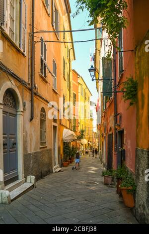 Blick auf eine schmale Gasse im mittelalterlichen Fischerdorf mit den typischen bunten Häusern und Touristen im Sommer, Lerici, La Spezia, Ligurien, Italien Stockfoto