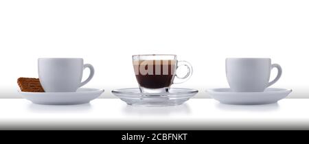 Eine Reihe von 3 Glas und weißen Espresso Tassen und Untertassen voller glatter Espresso Kaffee, auf einer weißen Bar oder Tischplatte mit weißem Hintergrund Stockfoto