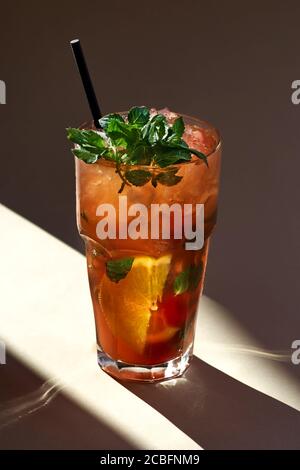 Red Mojito Cocktail mit Eis, Minzblätter auf Papier Hintergrund in selektiver Fokus, Sonnenlicht Stockfoto