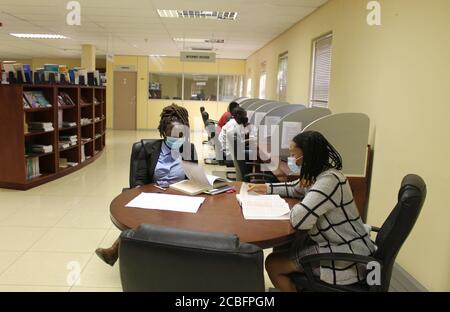 Windhoek, Namibia. August 2020. Menschen mit Gesichtsmasken lesen Bücher in einem Ressourcenzentrum in Windhoek, Namibia, 11. August 2020. Namibia ist nach steigenden COVID-19-Fällen, die jetzt über 3,000 liegen, auf Stufe drei der Sperre zurückgekehrt, sagte Präsident Hage Geingob am Mittwoch. Quelle: Ndalimpinga Iita/Xinhua/Alamy Live News Stockfoto