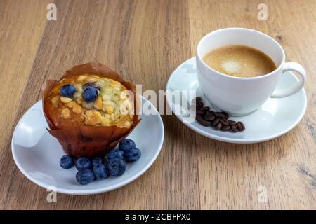 Blaubeer Muffin und Tasse Kaffee auf Holztisch Stockfoto