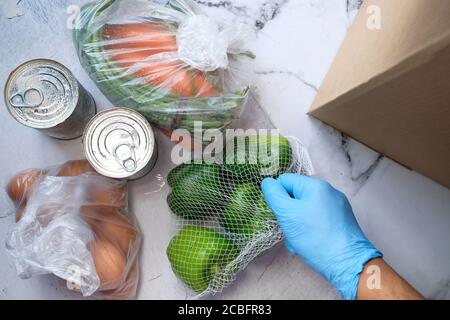 Lieferung von Waren an die Tür. Kommissionierer Verpackung Lebensmittel in einem Karton-Boxen. Stockfoto