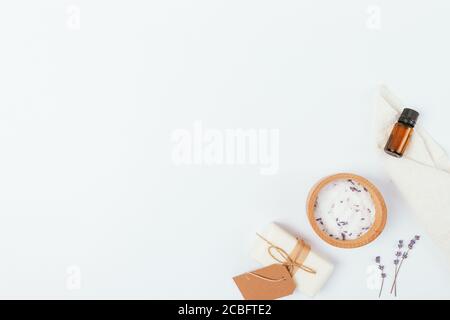 Naturbadkosmetik handgemachte Seife, Meersalz, ätherisches Aromaöl und Lavendelblüten auf weißem Hintergrund mit Kopierraum. Stockfoto