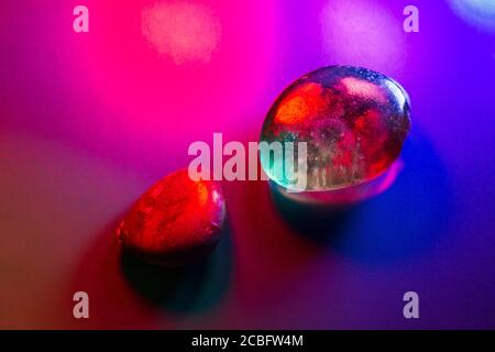 Zwei getaumelte Mineralsteine, bunt beleuchtet, mit abstrakten Details. Stockfoto