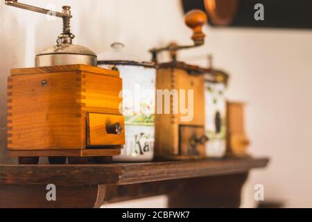 Alte Handmühle und Behälter für Zucker und Kaffee auf Ein Holzregal Stockfoto