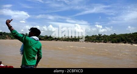 DISTRIKT JABALPUR, INDIEN - 24. AUGUST 2019: Ein indischer Mann klickt Selfie rund um narmada Fluss an offenen schönen natürlichen Ort. Stockfoto