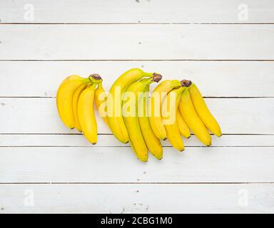 Bananenbünde auf weißen Holzbrettern. Stockfoto