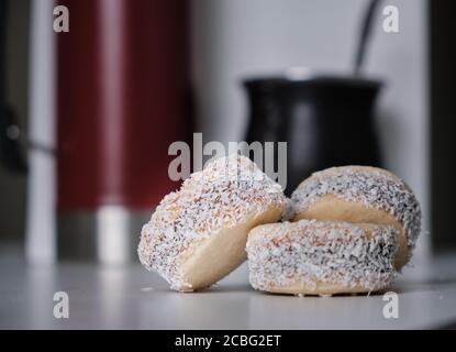 Argentinische Tradition: Nahaufnahme von köstlichen Maisstärke-Alfajores auf dem Tisch vor dem heißen Aufguss von Yerba Mate Stockfoto