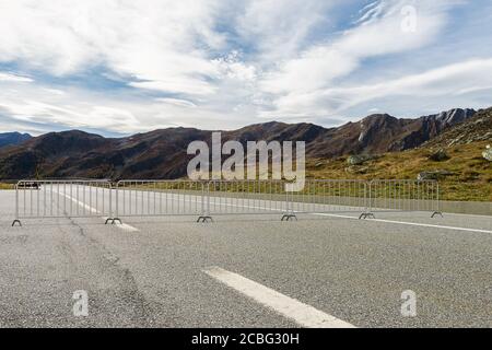 Stahlbarrikaden, die über die Straße gesetzt sind, blockieren die Passage - Ein Blick auf die Berge im Hintergrund - 3d Abbildung Stockfoto