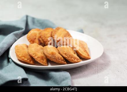 Typische kolumbianische Empanadas werden in der Regel mit würziger Sauce auf Beton serviert Oberfläche Stockfoto