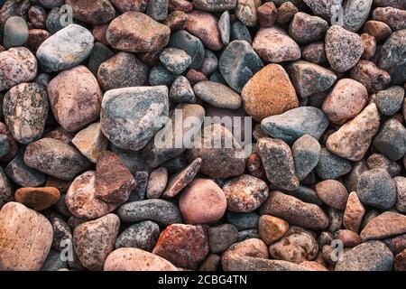 Textur mit bunten Steinen am felsigen Strand Stockfoto