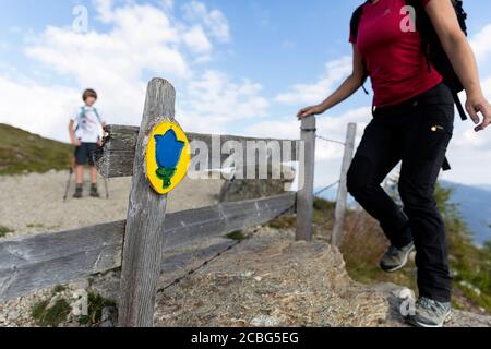 Mutter klettert über einen Step-Stile, Sohn wartet auf sie, Liebestrail, Granattor, Gipfelkreuz, Lammersdorf, Nockberge, Kärnten, Österreich Stockfoto