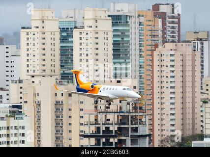 Embraer Phenom 300 Landung in Congonhas Flughafen mit Sao Paulo Gebäude hinter. Business Jet-Flugzeuge am zentral gelegenen Flughafen in Brasilien. Stockfoto