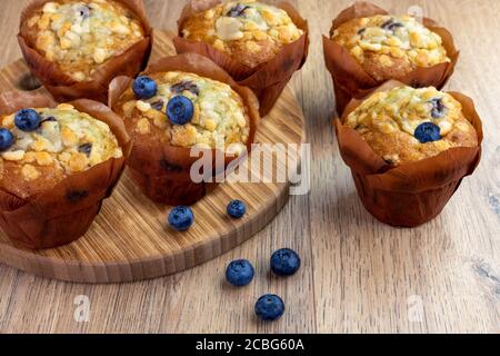 Heidelbeer-Muffins mit verstreuten Beeren auf dem Holztisch Stockfoto