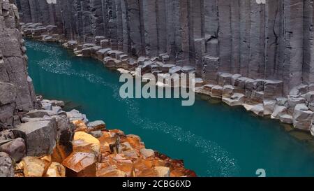 Türkisblaues Wasser und Basaltsäulen im Studlagil Basalt Canyon In Ostisland Stockfoto