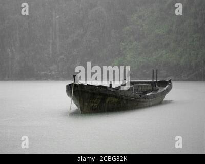 Ruderboot im Regen an der Halong Bay Stockfoto