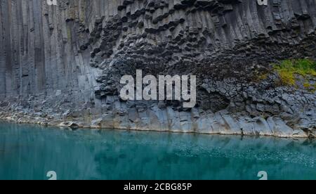 Türkisblaues Wasser und Basaltsäulen im Studlagil Basalt Canyon In Ostisland Stockfoto