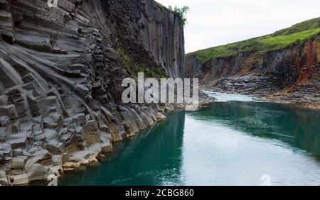 Türkisblaues Wasser und Basaltsäulen im Studlagil Basalt Canyon In Ostisland Stockfoto