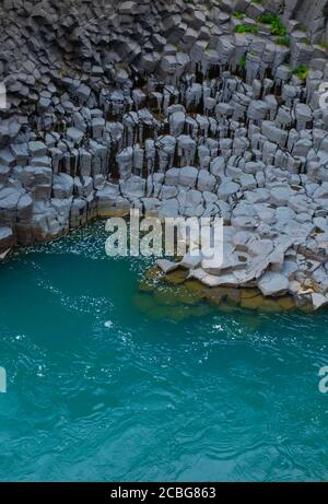 Türkisblaues Wasser und Basaltsäulen im Studlagil Basalt Canyon In Ostisland Stockfoto