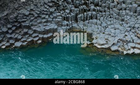 Türkisblaues Wasser und Basaltsäulen im Studlagil Basalt Canyon In Ostisland Stockfoto