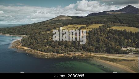 Schottlands Arran Island Landscape Luftaufnahme: Wälder, Wiesen, Berge am Sommertag. Wolken auf der Skyline in der Nähe von Goat Fell Peak. Epische Szene von Stockfoto