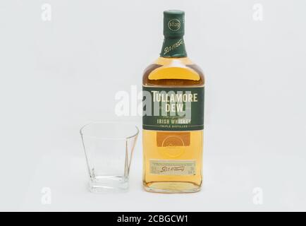 KIEW, UKRAINE - 17. AUGUST 2019: Flasche Tullamore TAU Irischer Blended Whiskey und Glas Nahaufnahme vor weißem Hintergrund. Es wird von William G produziert Stockfoto