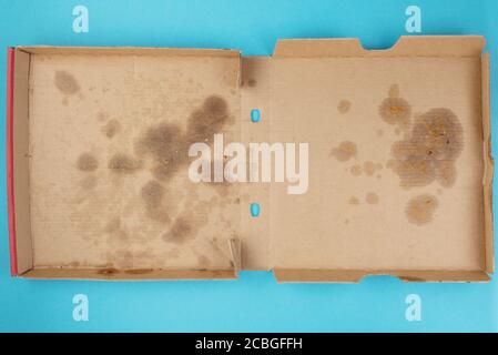 Oben Blick auf fettige leere Lieferung Pizzabox auf blau Hintergrund Stockfoto