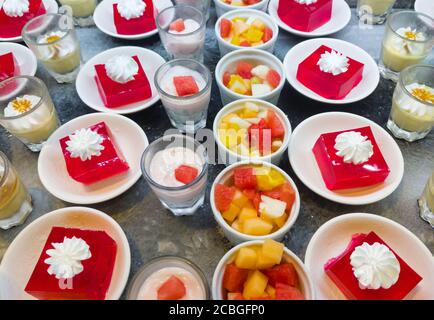 Abwechslungsreiches Dessert-Mix (Obstsalat, Gelee, Kaffee Panna Cotta, Erdbeerjoghurt) auf dem kalten Tablett für Frische im Restaurant. Stockfoto