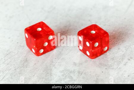 Zwei durchscheinende rote Würfelwürfelwürfelchen auf weißem Brett, das Schlange zeigt Augen (Doppelte Zahl 1) Stockfoto