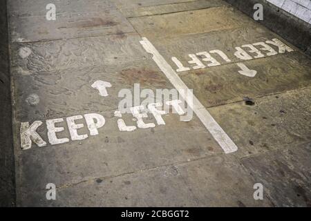 HALTEN SIE SICH LINKS geschrieben auf Asphalt Boden in Fußgängertunnel Weg Stockfoto