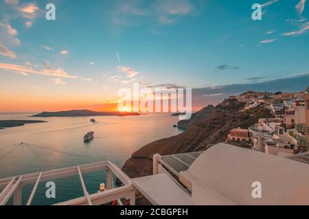 Atemberaubende Landschaft Abendansicht von Fira, Caldera, Vulkan von Santorini, Griechenland mit Kreuzfahrtschiffen bei Sonnenuntergang. Reiseziel wolkig dramatischer Himmel. Stockfoto