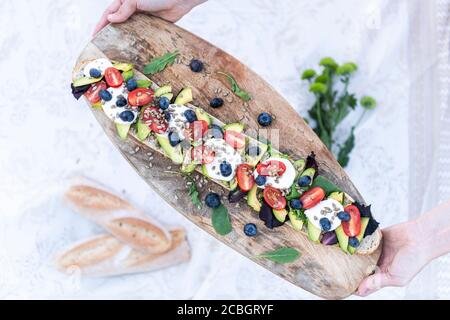 Sommerpicknick mit vegetarischem Baguette aus Avocado, Tomaten und Mozarella-Käse Stockfoto