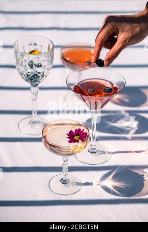 Bunte alkoholische Getränke, von Fruchtcocktails auf weißem Hintergrund an einem heißen Sommertag unter der Sonne Stockfoto