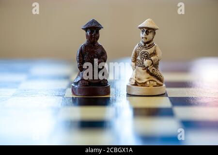 Nahaufnahme des schwarz-weißen Schachspieles, das auf einem Schachbrett sitzt. Schwarz gegen weiße Bauern. Stockfoto