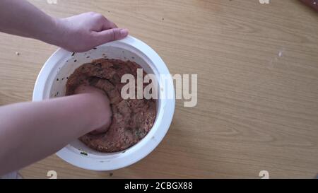 Hacksteak, Fleischbällchen machen, Hand kneten Fleisch Mischung in den Topf. Nahaufnahme Stockfoto