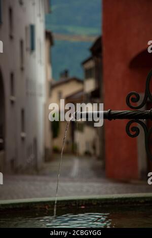 Eine flache Tiefe des Feldes abstraktes Bild eines dekorativen Metall-Brunnen mit Wasser läuft in Stein Pool schaffen Wellen. In der verschwommenen Backgr Stockfoto