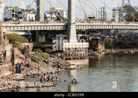 Bhopal, Madhya Pradesh, Indien - März 2019: Eine Gruppe von jungen indischen Jungen, die im Wasser des Upper Lake in Bhopal unter der Raja Bhoj Brücke baden Stockfoto